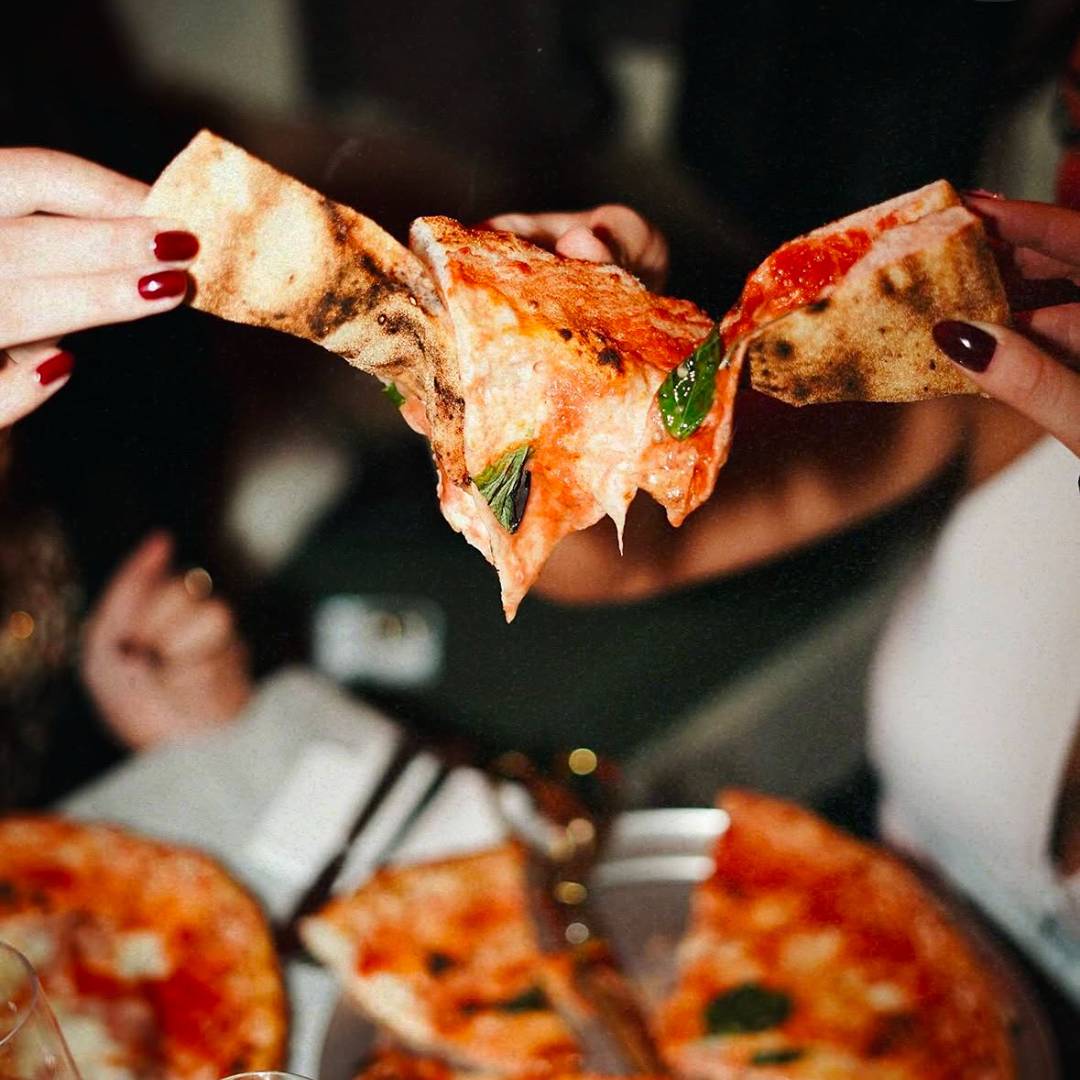 Guests sharing Neapolitan pizza